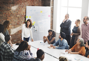 Group of people in a meeting near a whiteboard