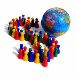 Multicolor small figures representing people arraying in a dollar sign next to a small globe